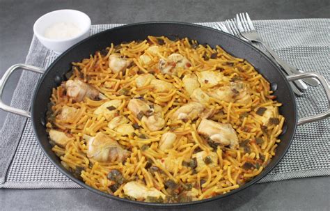 Fideuá de conejo y pollo con fideos gordos en paellera