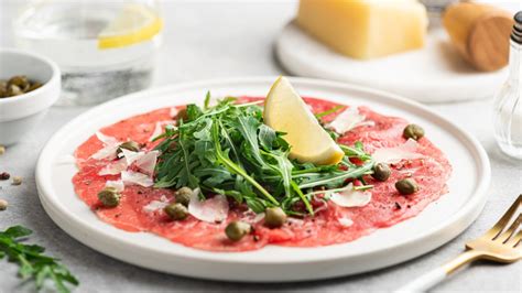 Plato de carpaccio de res tradicional con rúcula y parmesano