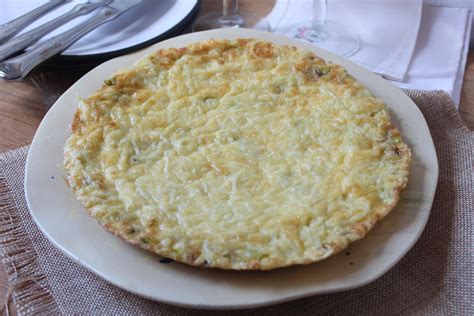Tortilla de puerros servida en un plato con ensalada