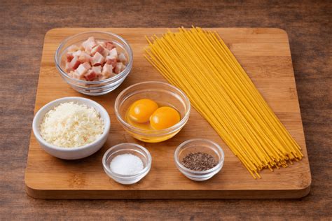 Ingredientes para espaguetis a la carbonara dispuestos en una mesa