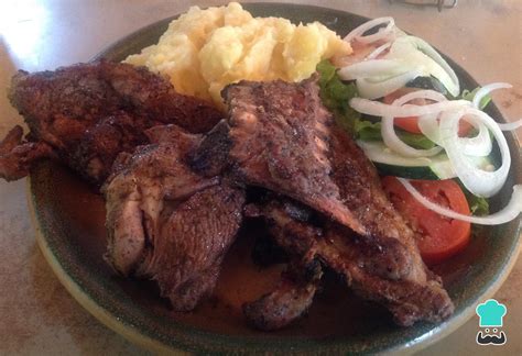 Plato de chivo asado servido con ensalada y yuca