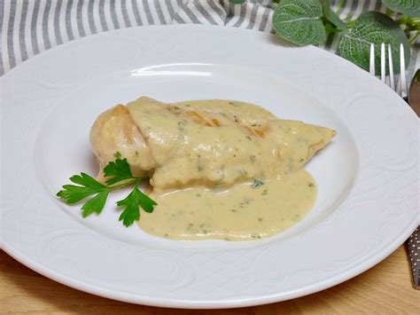 Pechuga de pollo troceada cocinándose en una sartén con salsa cremosa