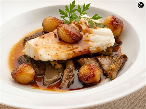 Plato gourmet de bacalao con setas y langostinos perfectamente emplatado