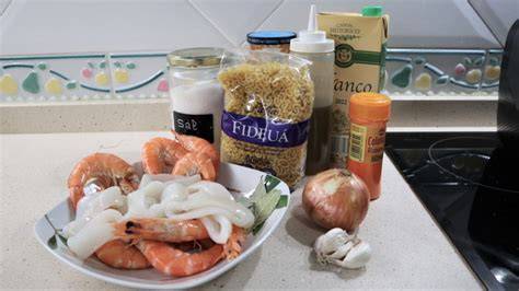 Ingredientes básicos para una fideuá de calamares: calamares, fideos, caldo, cebolla, ajo, pimiento, tomate