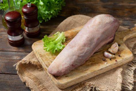 lengua de vaca cruda sobre tabla de cortar