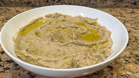 Crema de berenjena servida con pan de pita y hierbas