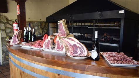 Interior rústico de la Parrilla-Bodega El Viejo Galeón con paredes de piedra