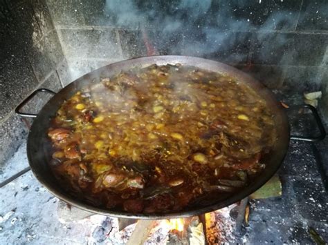 Preparación de paella valenciana con leña de naranjo