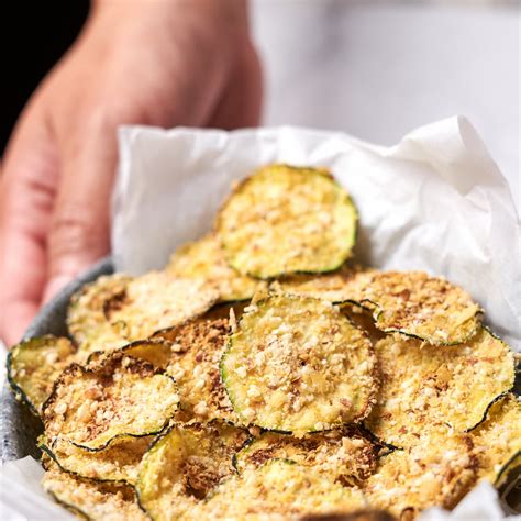 Chips de calabacín dorados y crujientes en la cesta de la freidora de aire
