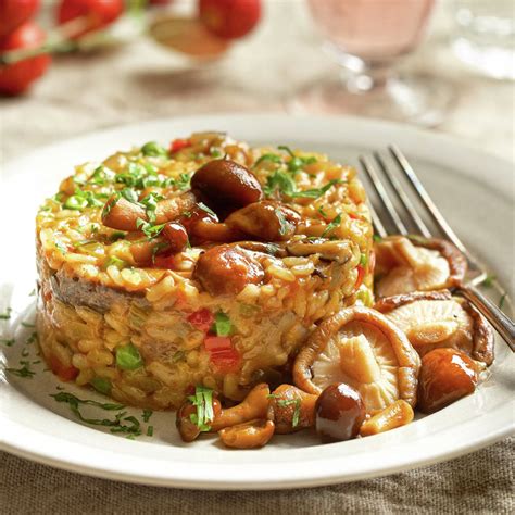 Plato de arroz meloso con alcachofas y setas portobello humeante