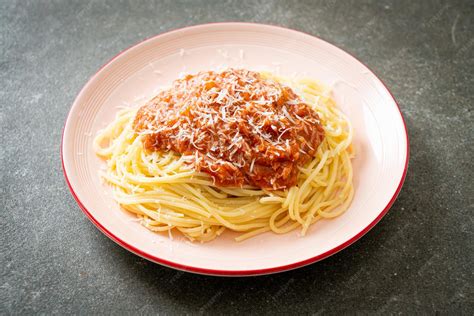 Servicio de espaguetis a la boloñesa con queso parmesano