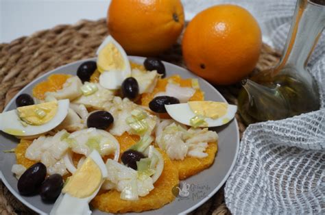 Plato de bacalao con salsa de naranja y frutos secos decorado con rodajas de naranja