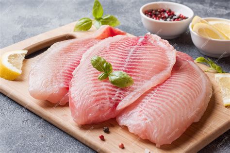 Pescado fresco en una tabla de cortar con limón y hierbas