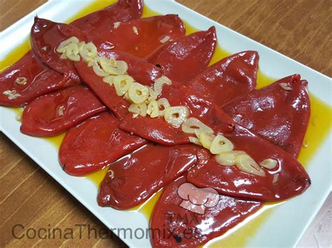 Pimientos del piquillo confitándose en una sartén con ajos y azúcar