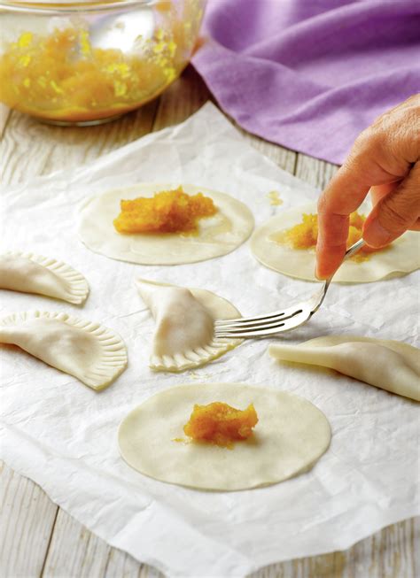 Empanadillas rellenas listas para sellar con un tenedor