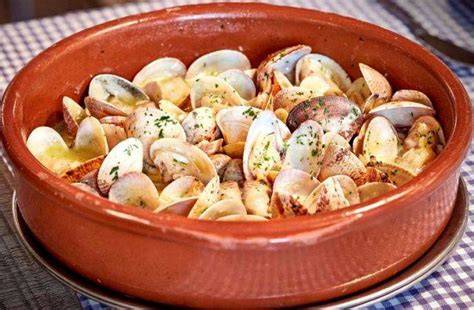 Almejas a la marinera servidas en una cazuela de barro