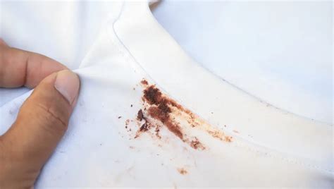 Persona limpiando una mancha de chocolate de una camisa