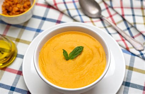 Crema de calabaza en un tazón con hierbas frescas