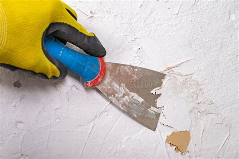 Primer plano de una espátula de goma eliminando restos de lechada