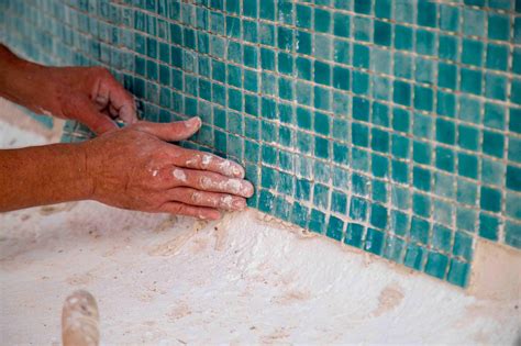 Persona frotando las juntas de los azulejos con un cepillo y producto casero