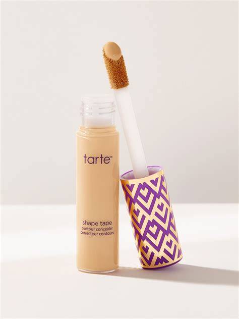 Mujer aplicando corrector Tarte Shape Tape en sus ojeras