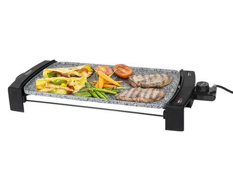 Plancha eléctrica de piedra preparando diversos vegetales y carnes