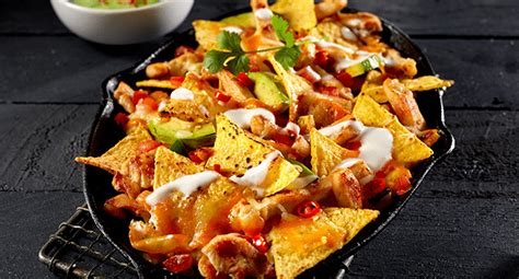 Trozos de pollo crujientes con nachos acompañados de salsa de yogur
