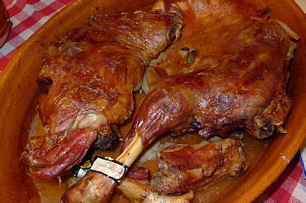 Plato de lechazo asado tradicional en una cazuela de barro