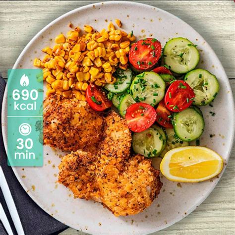 Plato de pechuga de pollo crujiente con maíz servido