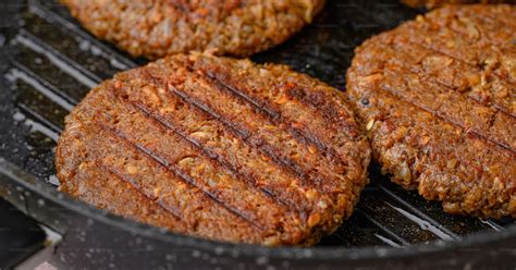 Hamburguesa de ternera cocinándose en una sartén a fuego alto