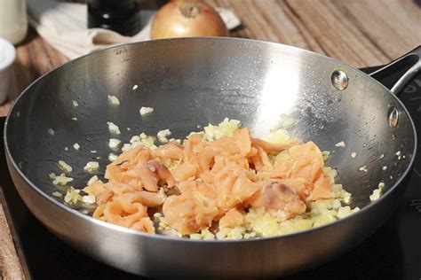 Proceso de cocción de pasta con salmón en una sartén
