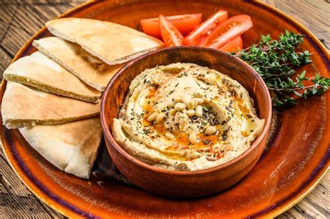 Hummus servido con pan de pita y decorado