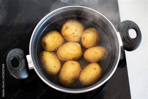 Patatas cociéndose enteras en una olla con agua