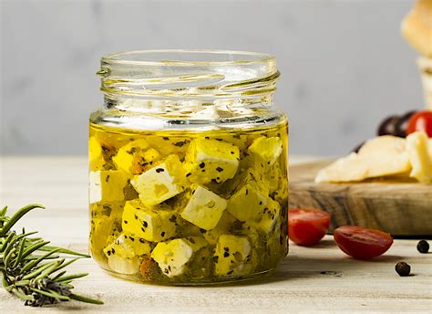 Frasco de vidrio con queso curado sumergido en aceite de oliva