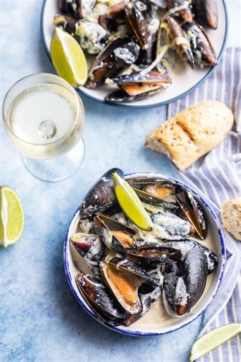 Mejillones servidos en un plato con pan y vino