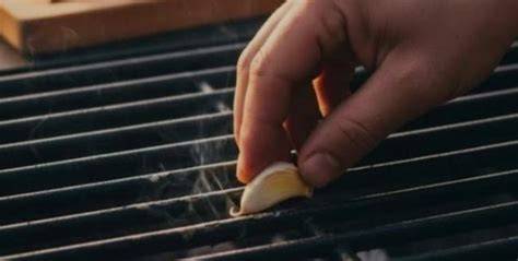Técnica de frotar ajo en una parrilla de acero inoxidable