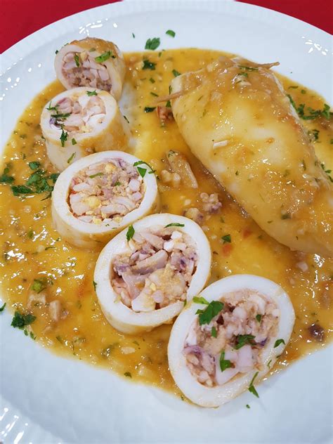 Plato de calamares rellenos de pollo servidos en salsa