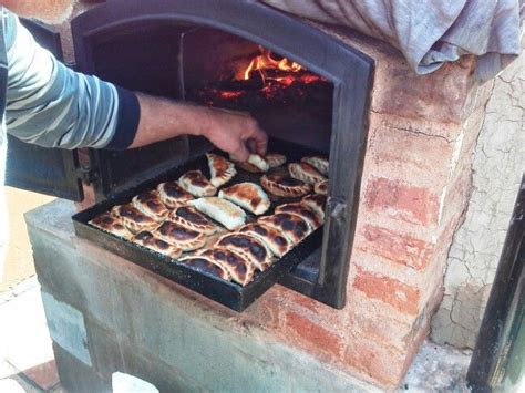 Empanadas tucumanas cocinándose en horno de barro