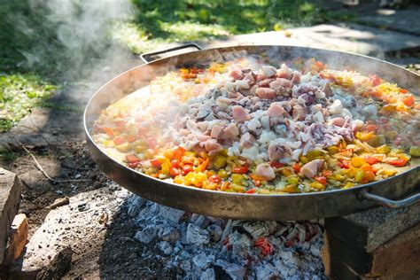 Paella valenciana tradicional en una paellera sobre fuego de leña
