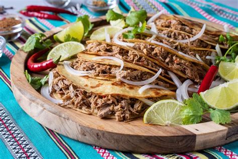 Tacos de barbacoa servidos con limón y cilantro