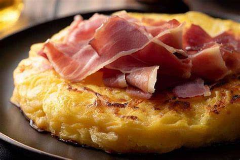 Tortilla francesa y lonchas de bacon sobre un solomillo abierto
