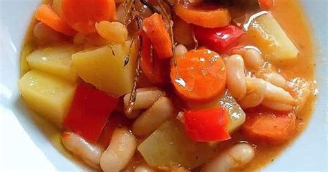 Alubias blancas cocinándose con hierbas aromáticas
