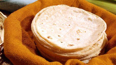 Tortillas de maíz en un canasto envueltas en tela
