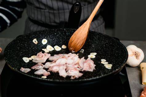 Cebolla y ajo pochándose en una sartén