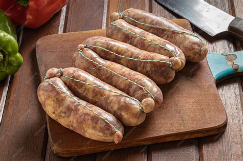 chorizos frescos en una tabla de cortar siendo pinchados