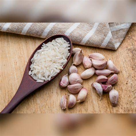 Ajo picado y cuchara de palo para el aderezo base del arroz