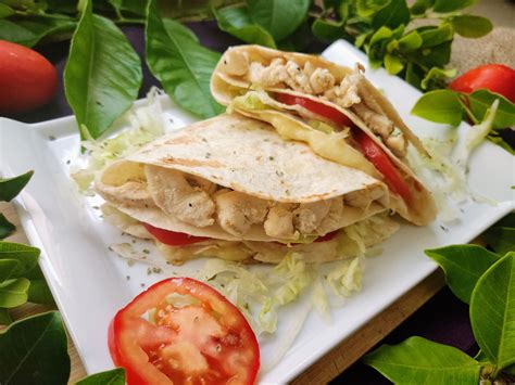 Bocadillos de pollo con tortillas mexicanas, mostrando el relleno de pollo, queso, cebolla y pepinillos.