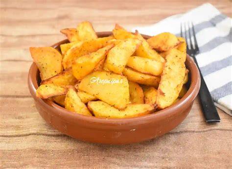 Airfryer con una cesta llena de patatas Cajún doradas