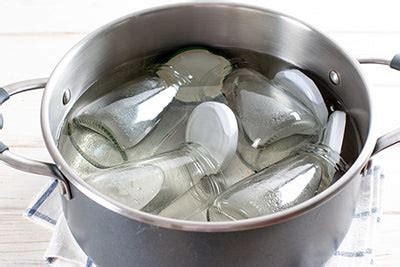 frascos de conservas de pimientos en agua hirviendo para esterilizar