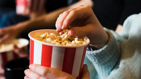 Jóvenes con un recipiente gigante de palomitas en el cine